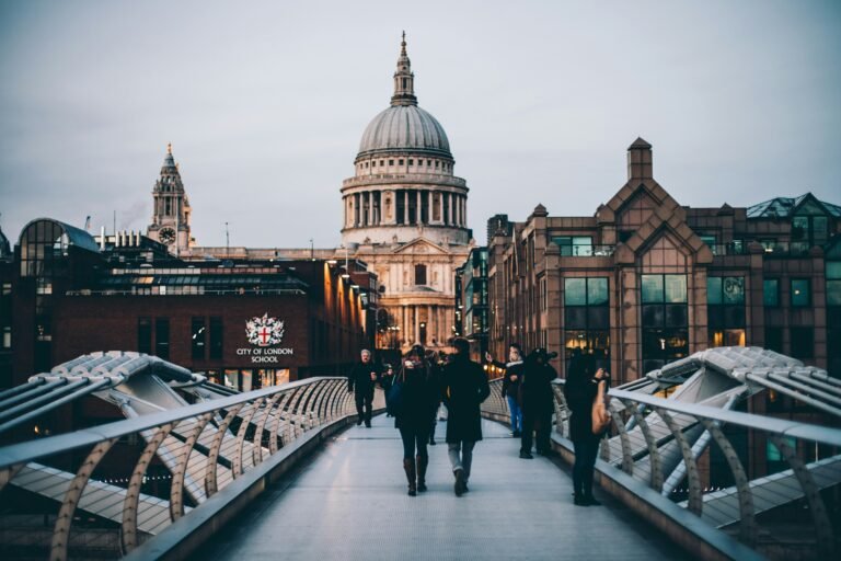 People walking on Millennium Bridge with St Paul's Cathedral in the background in London.