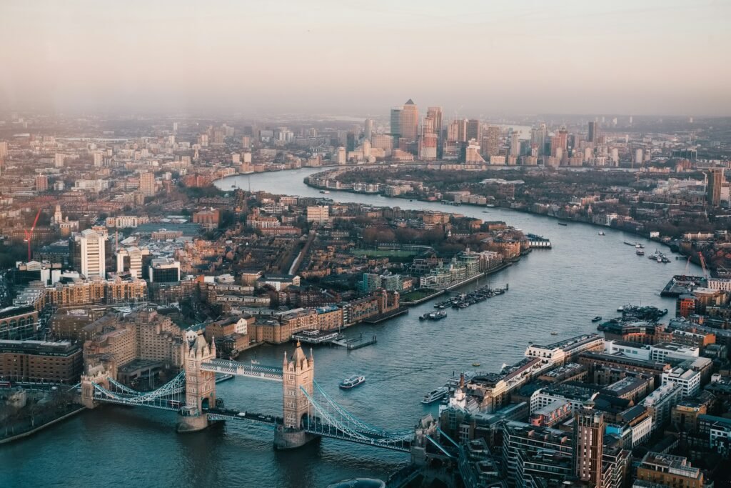 Aerial view of Tower Bridge over the River Thames with the London skyline and Canary Wharf in the distance.